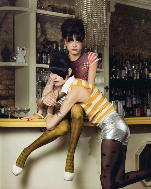 two women sitting on a bar wearing designer ben doctor