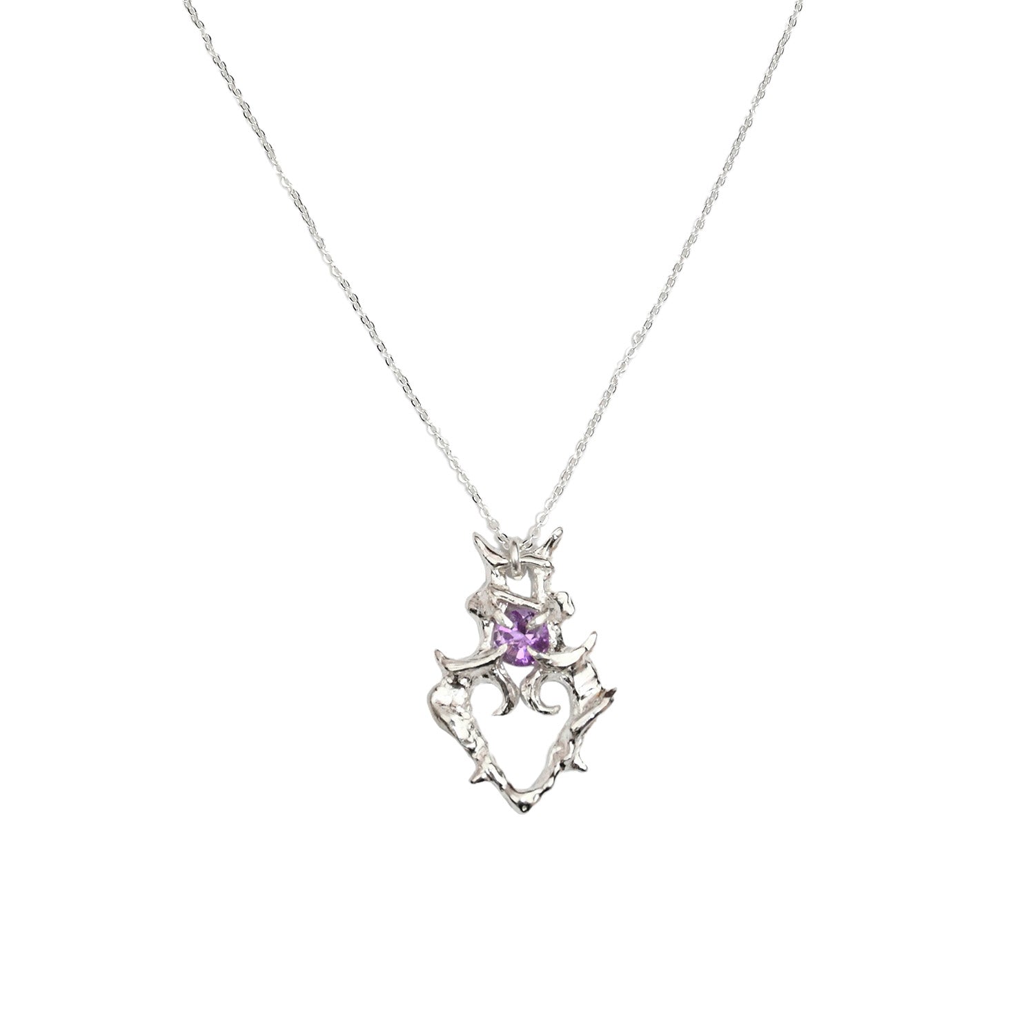 close up of silver necklace with heart shaped pendant with amethyst gemstone sitting above