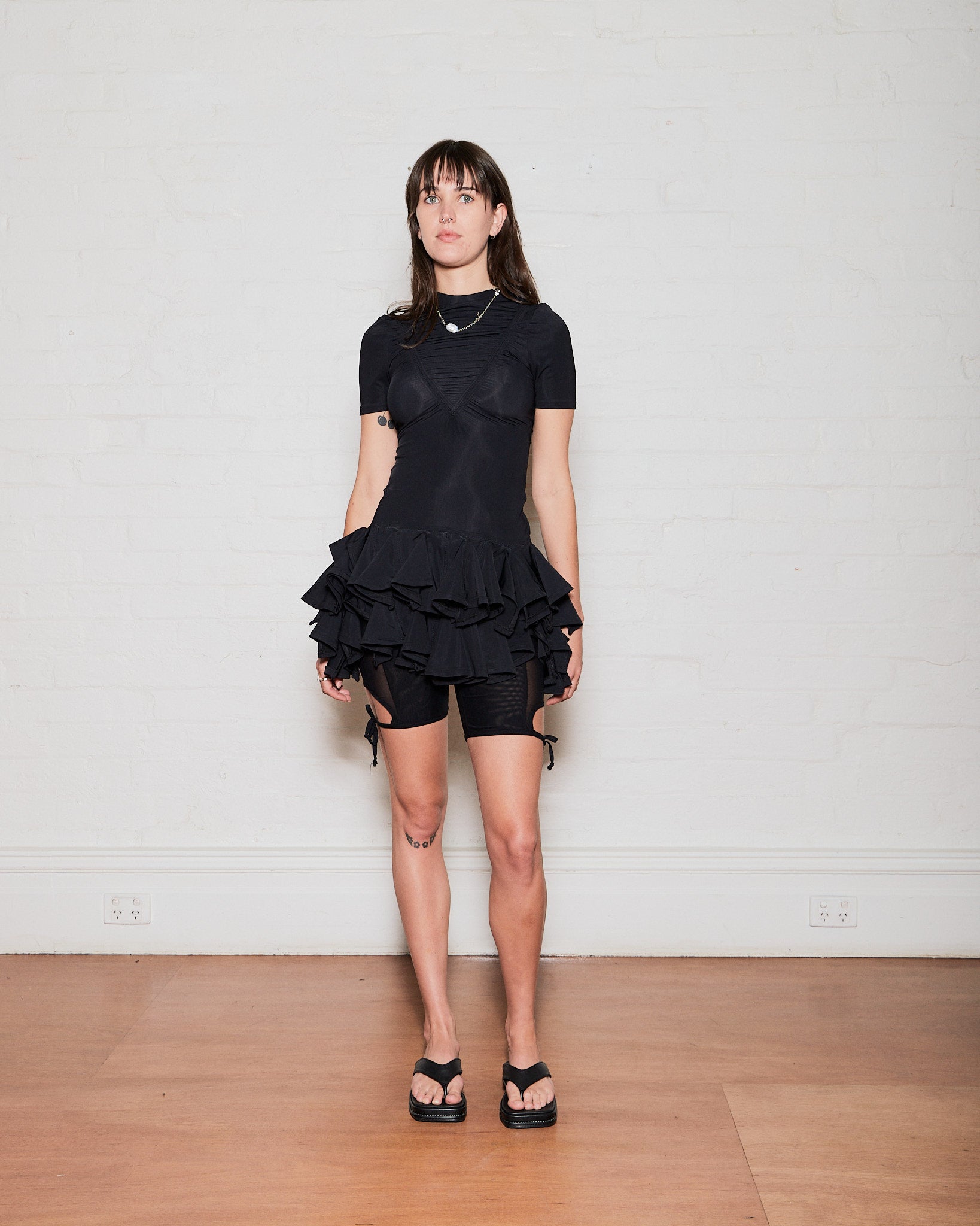 Black fitted tutu dress with short sleeves and ruffles at hem. Made by Australian independent designer Emily Watson. Sold in Melbourne clothing boutique called Error404store.